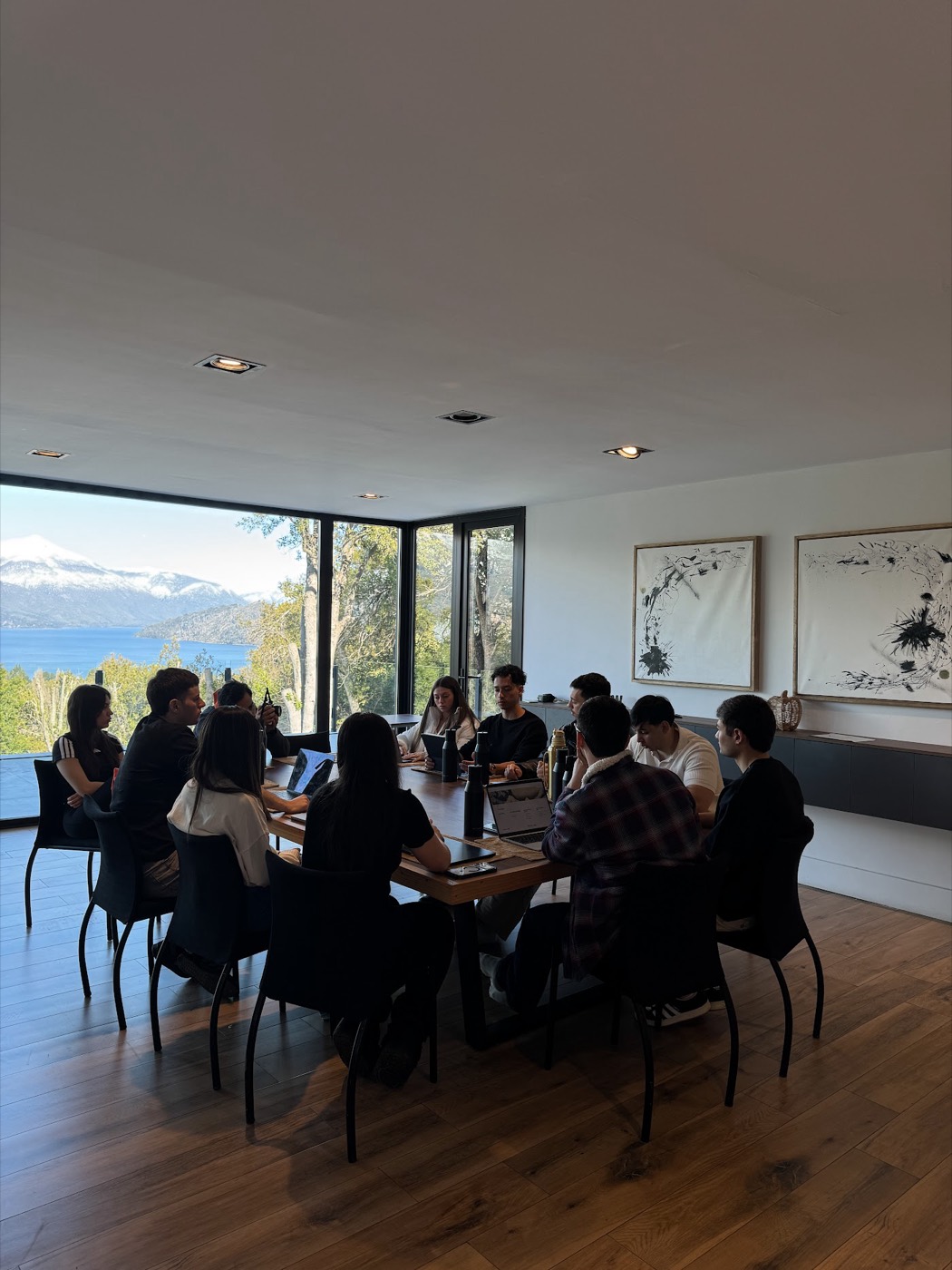 El grupo en una sesión de trabajo frente a ventanales con vista al lago