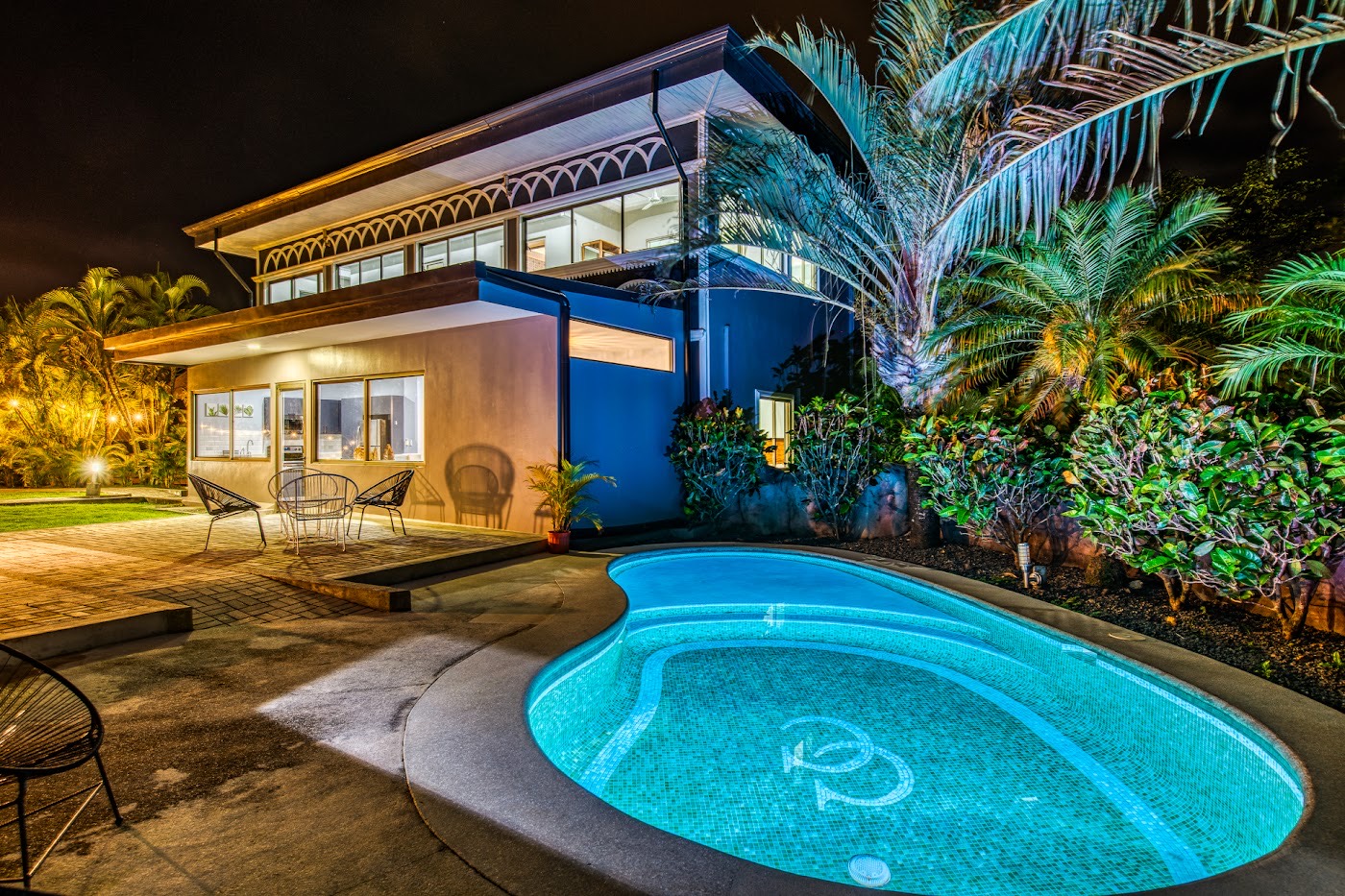 Piscina de la casa de noche entre palmeras